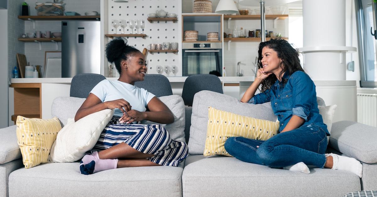 Young homeowner woman sitting on a sofa with a young female student 