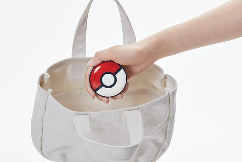 The Pokémon GO Plus accessory being placed in a bag.