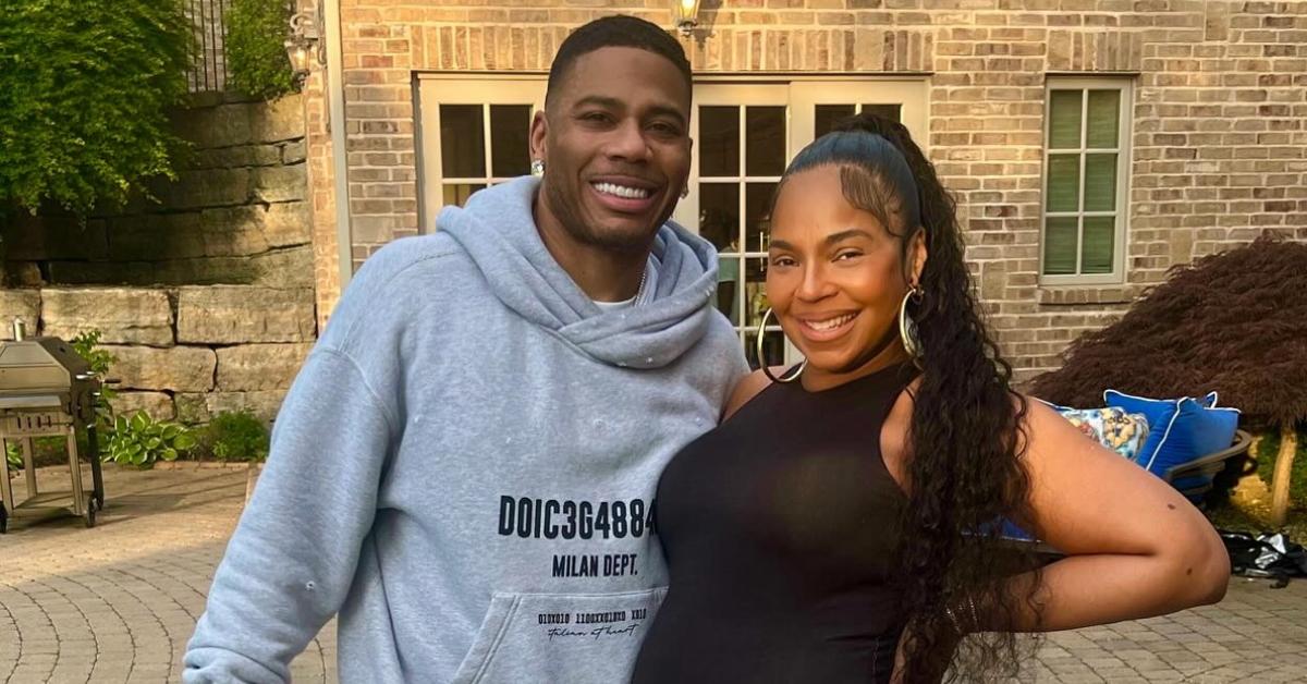 A pregnant Ashanti smiling with her husband, Nelly.