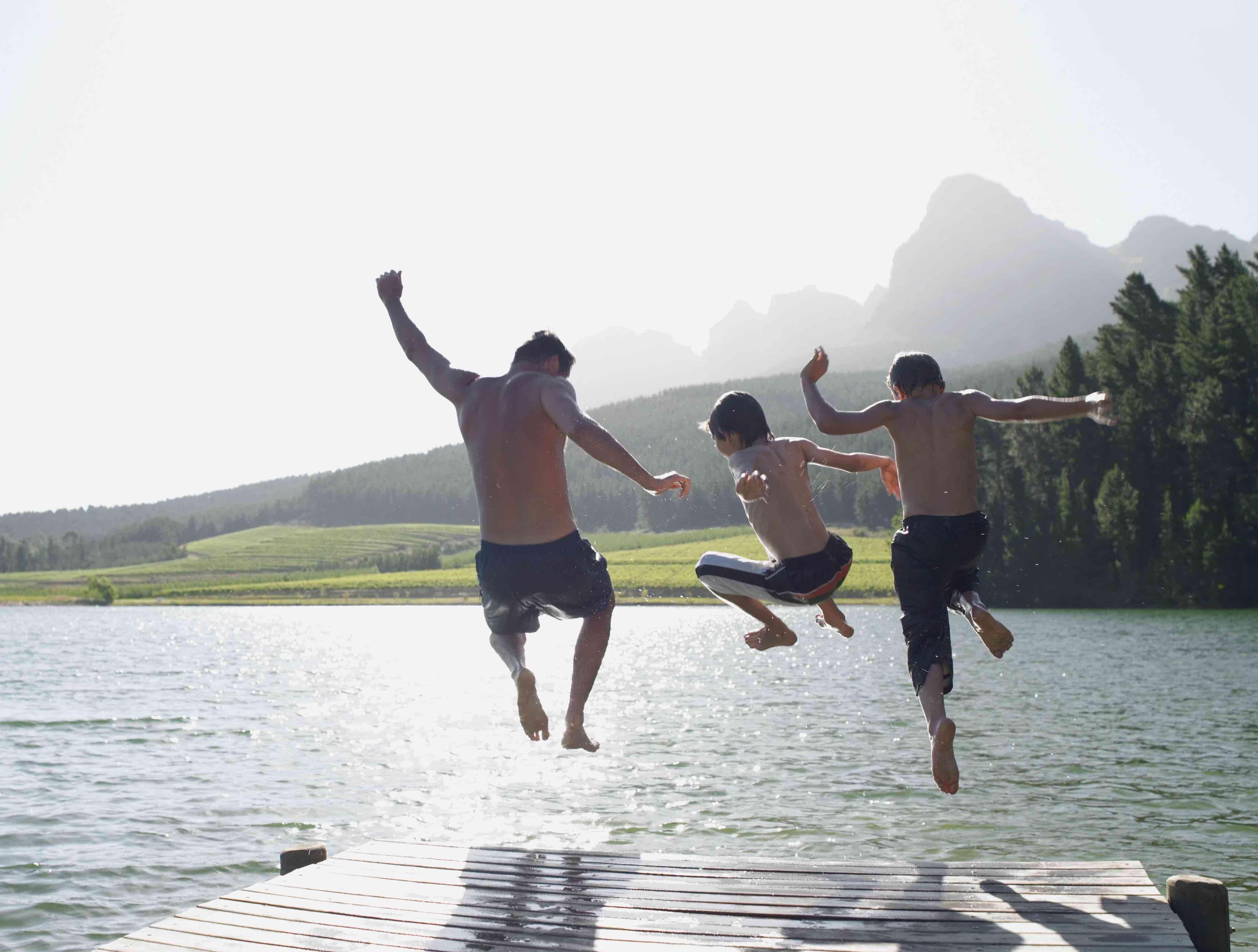 Family jumps into a lake.