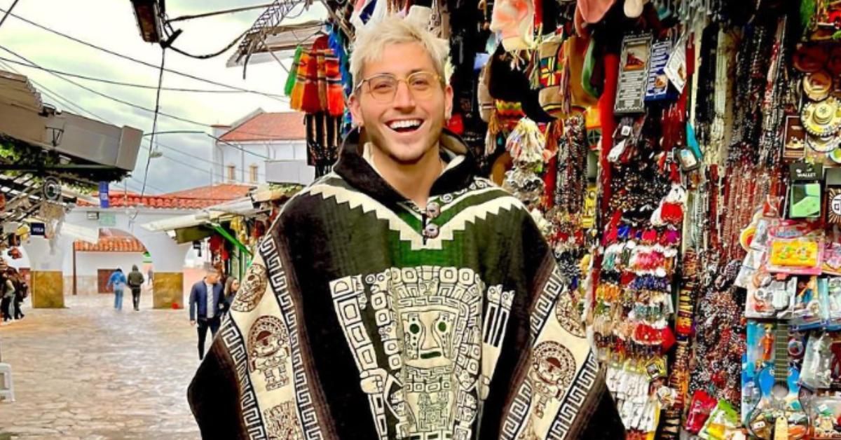 'The Circle' Season 6 cast member Myles Reed smiles while wearing a wool poncho in Cerro Monserrate