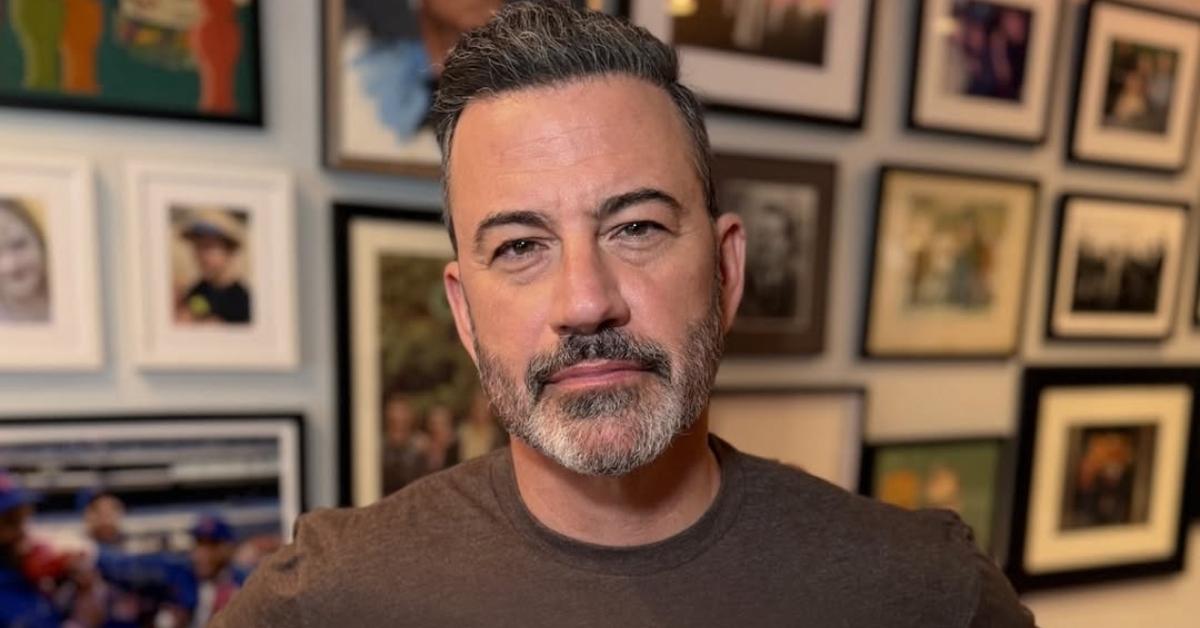 Jimmy Kimmel in front of a wall of framed photos in his home.