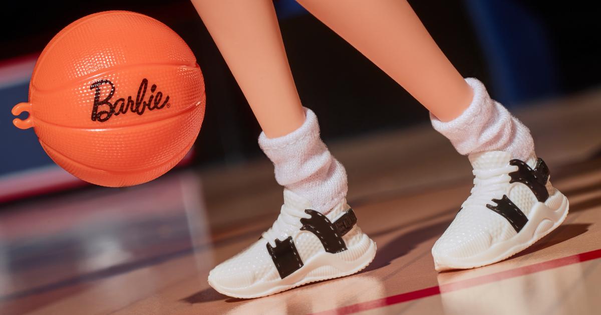 A close up of the Sue Bird Barbie role model doll's socks and sneakers. A "Barbie" basketball bounces beside the doll.