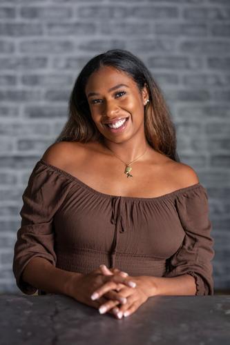 Jordan is dressed in a brown off-the-shoulder top, smiling for her official portrait for Season 2 of 'The Mole.'