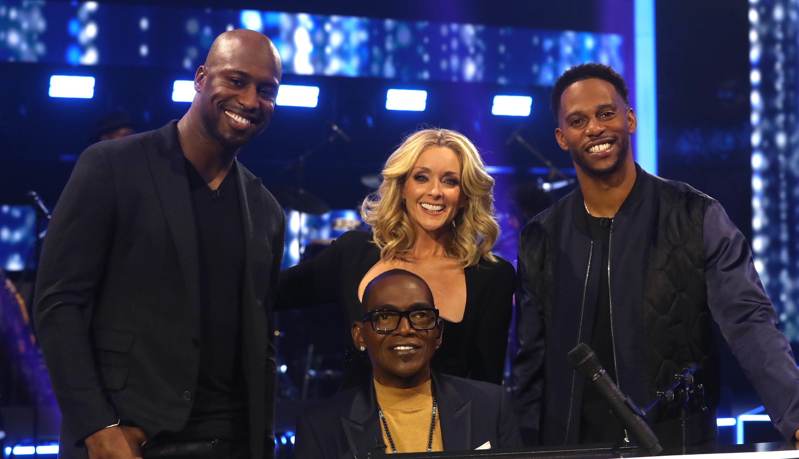 Vernon Davis and Victor Cruz with host Jane Krakowski and bandleader Randy Jackson during Season 2 of 'Name That Tune.'