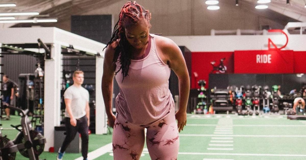 Ashley Michelle from 90 Day Fiance in a pink tank top and leggings in a gym