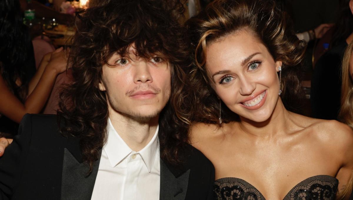 Maxx Morando and Miley Cyrus sit together at the 66th Grammy Awards.