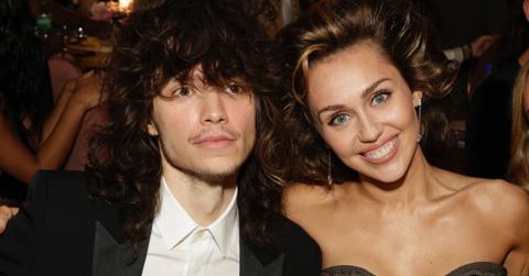 Maxx Morando and Miley Cyrus sit together at the 66th Grammy Awards.