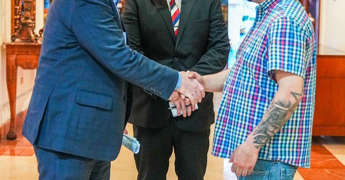 Senator Chris Van Hollen shaking Kilmar Abrego Garcia's hand.