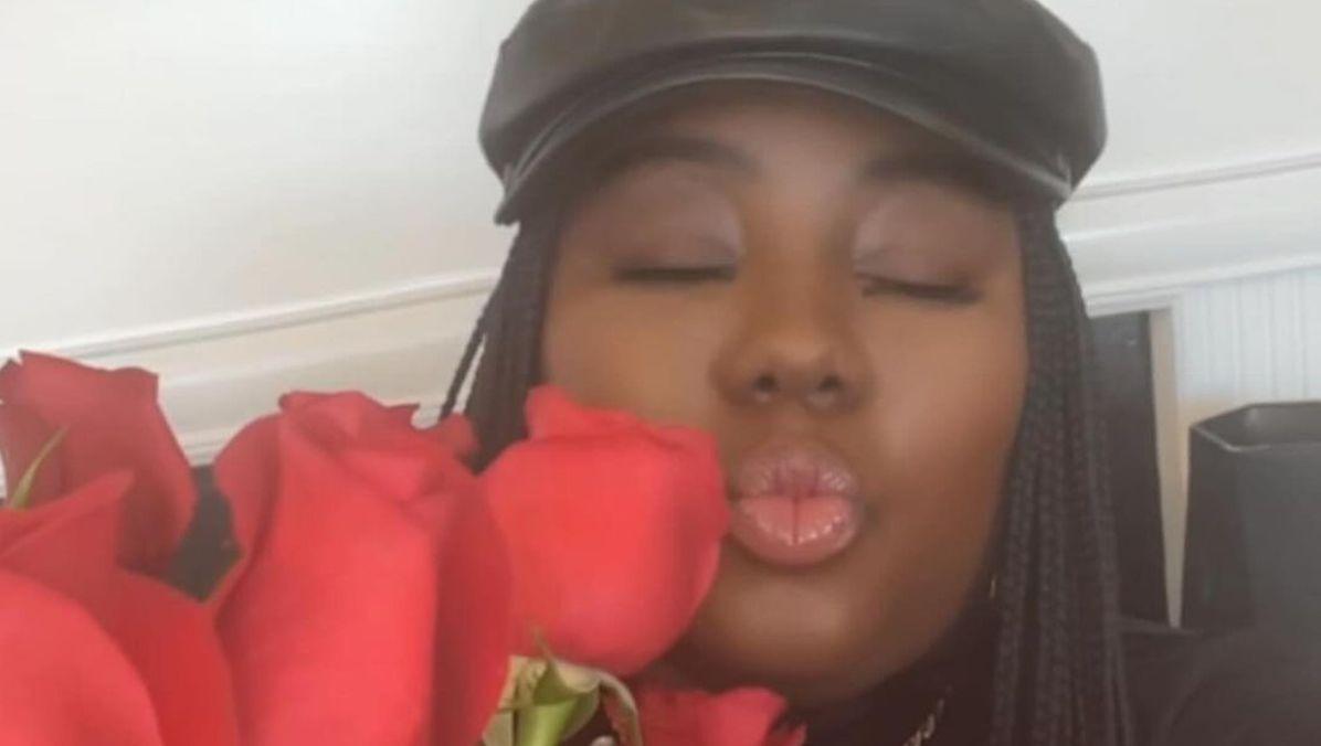 dasha kennedy aka the broke black girl making a kiss face with roses