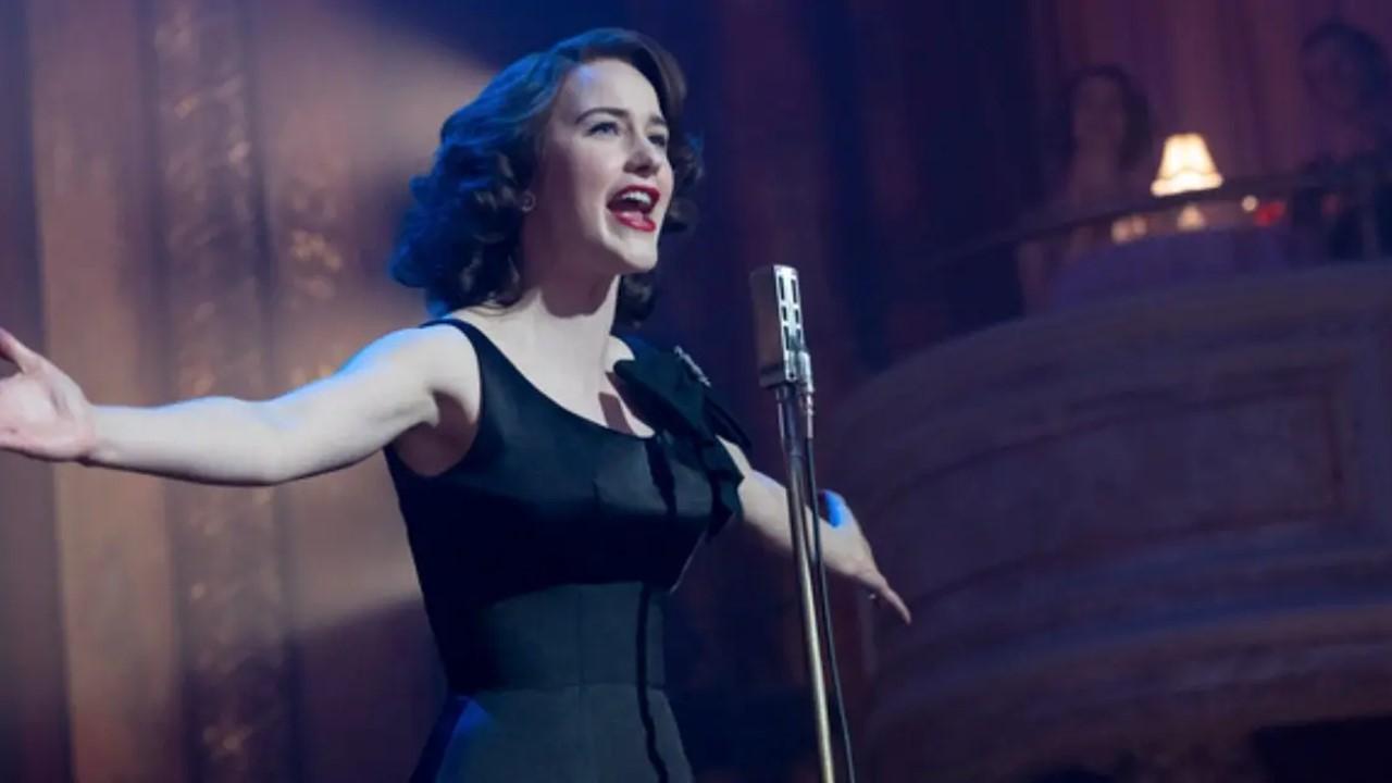 Midge (Rachel Brosnahan) in a elegant black dress as she performs a standup routine