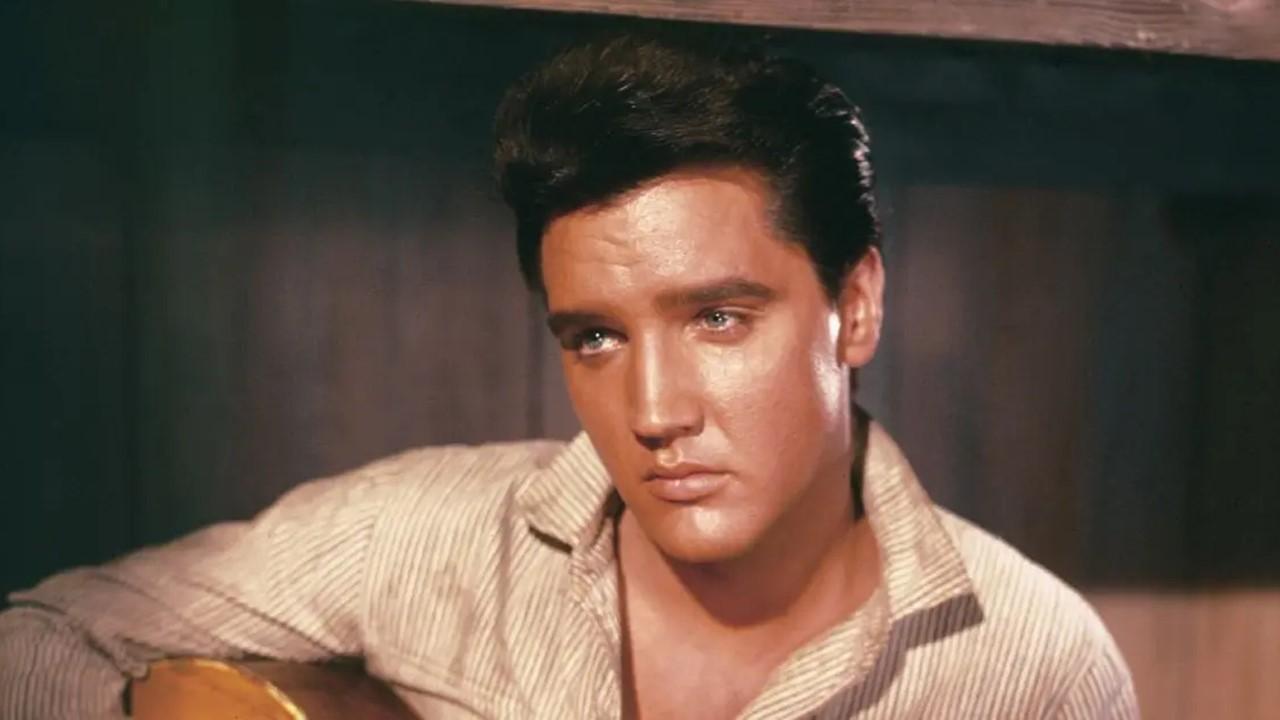 Elvis Presley holding an acoustic guitar