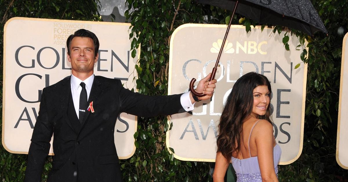Josh Duhamel holds an umbrella for Fergie at the Golden Globes.