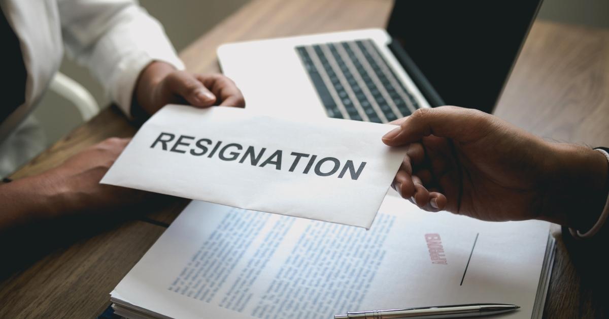 An employee handing a resignation envelope to the manager