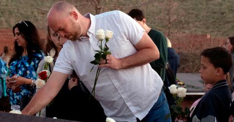 A former Columbine student places flowers at the memorial in Colorado