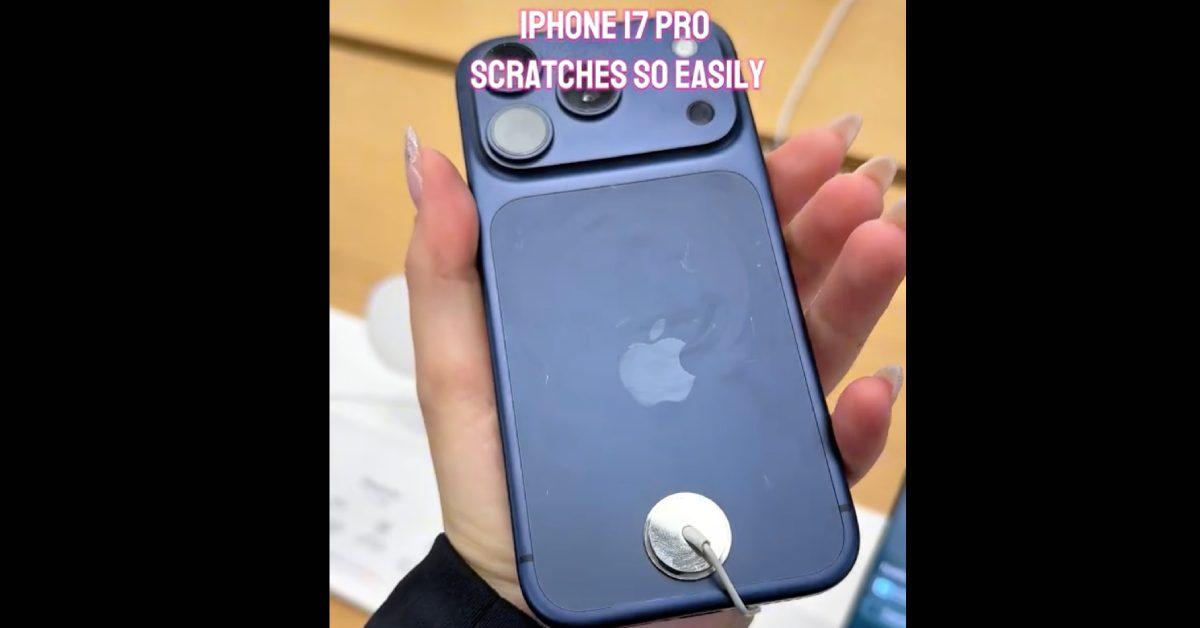 Customer holding scratched iPhone 17 in the Apple store.