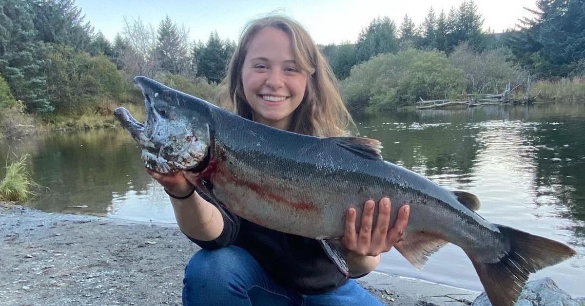 Sophia 'Bob' Nielsen holds a large dead fish with both of her hands