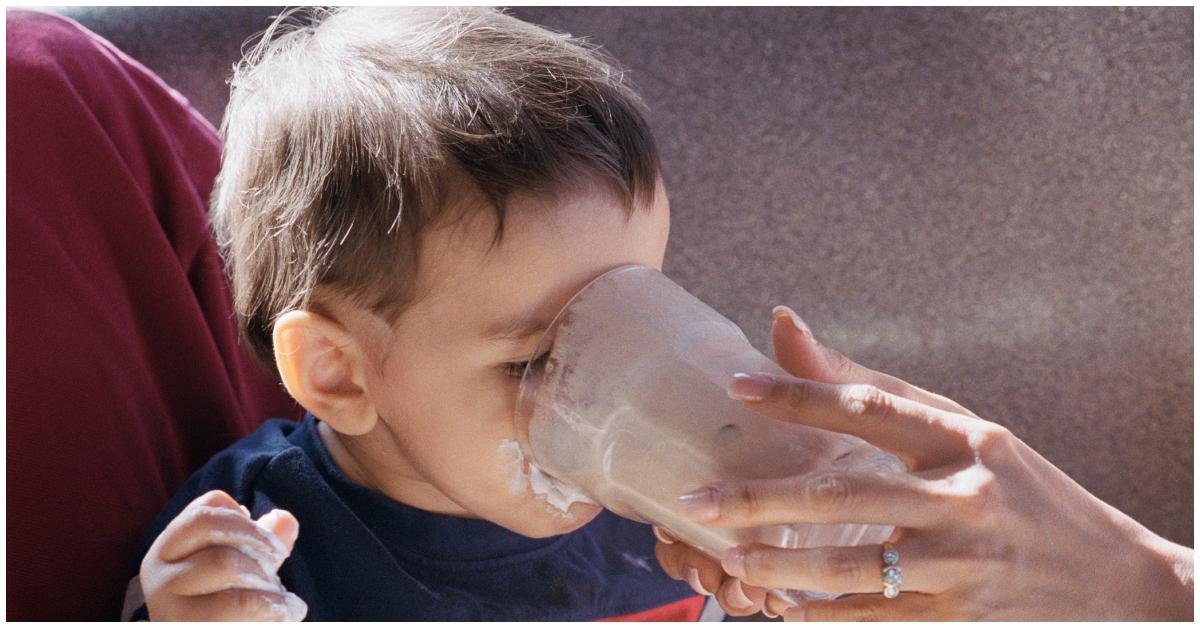 A toddler drinking at a restaurant