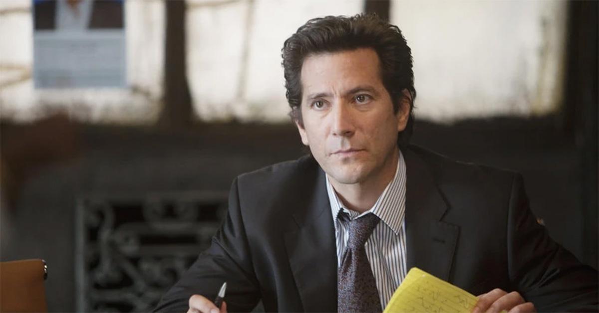 Henry Ian Cusick looking at documents in 'Scandal.' 