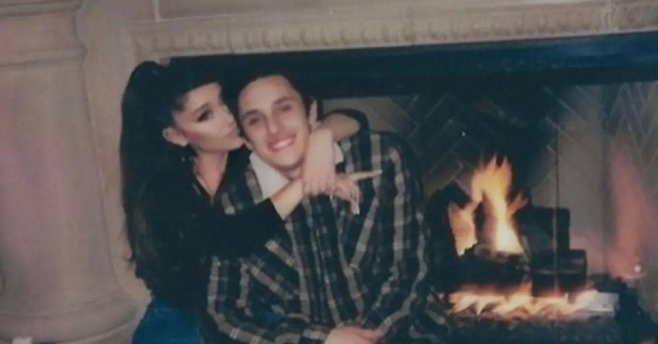 Ariana Grande and Dalton Gomez snuggled up next to a fireplace.