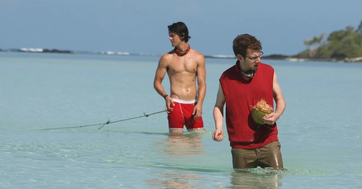 Cochran wearing his red sweater vest and holding a coconut in 'Survivor: South Pacific'