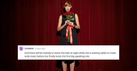 A woman stands on stage holding flowers.