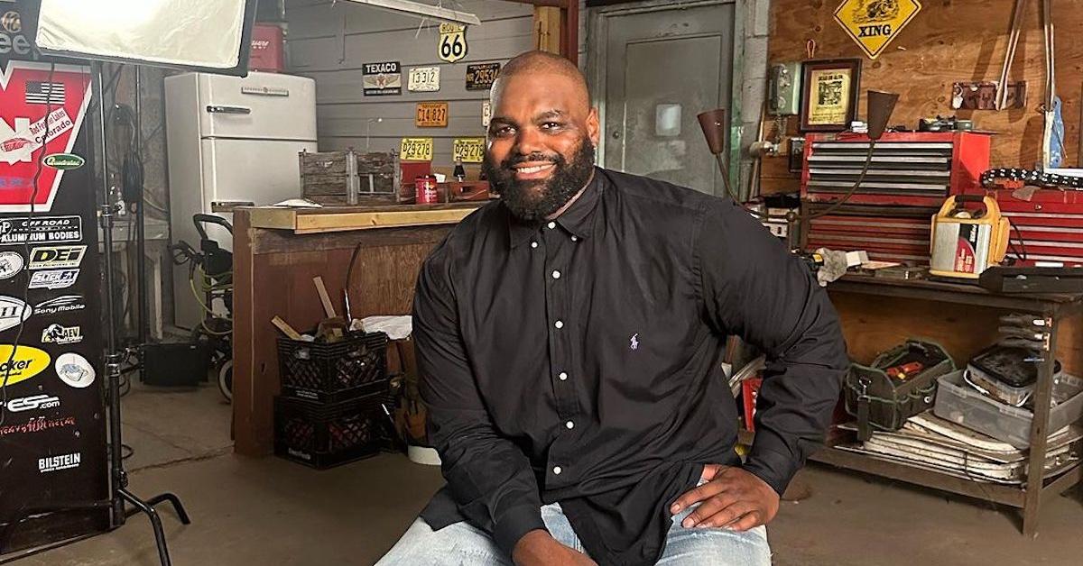 Retired NFL player Michael Oher sitting in a garage