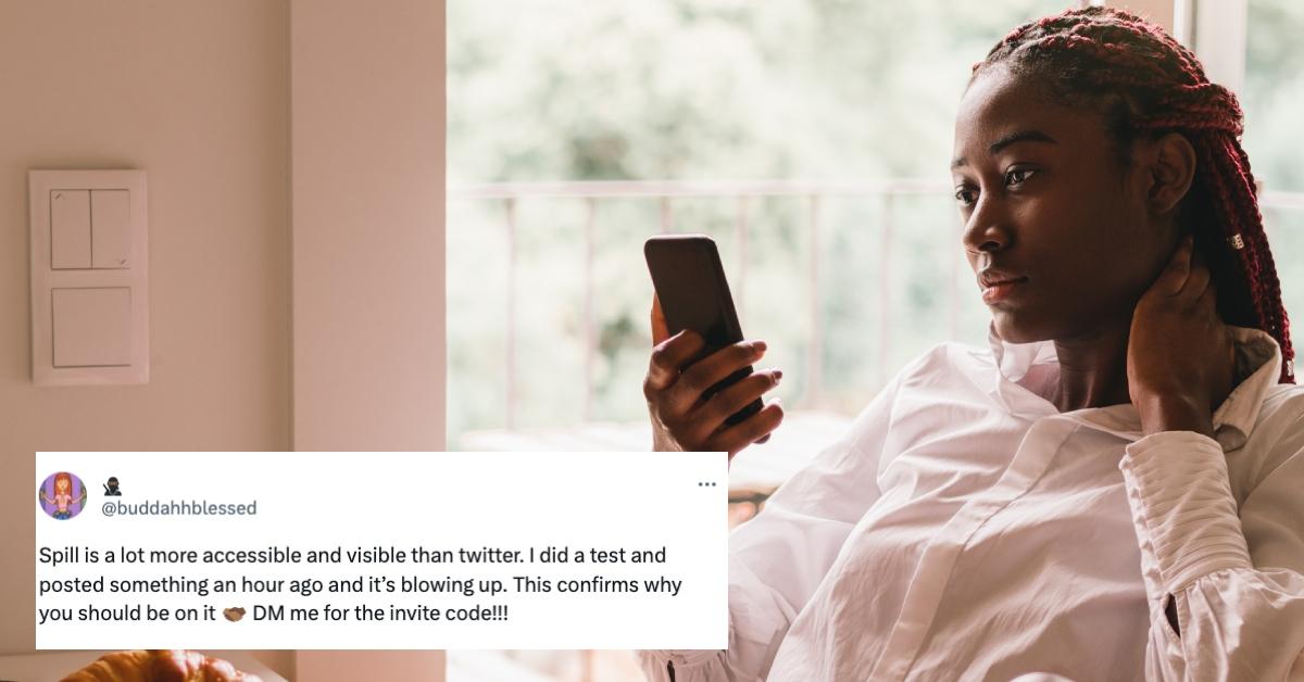 Black woman with red braids looks at her phone screen