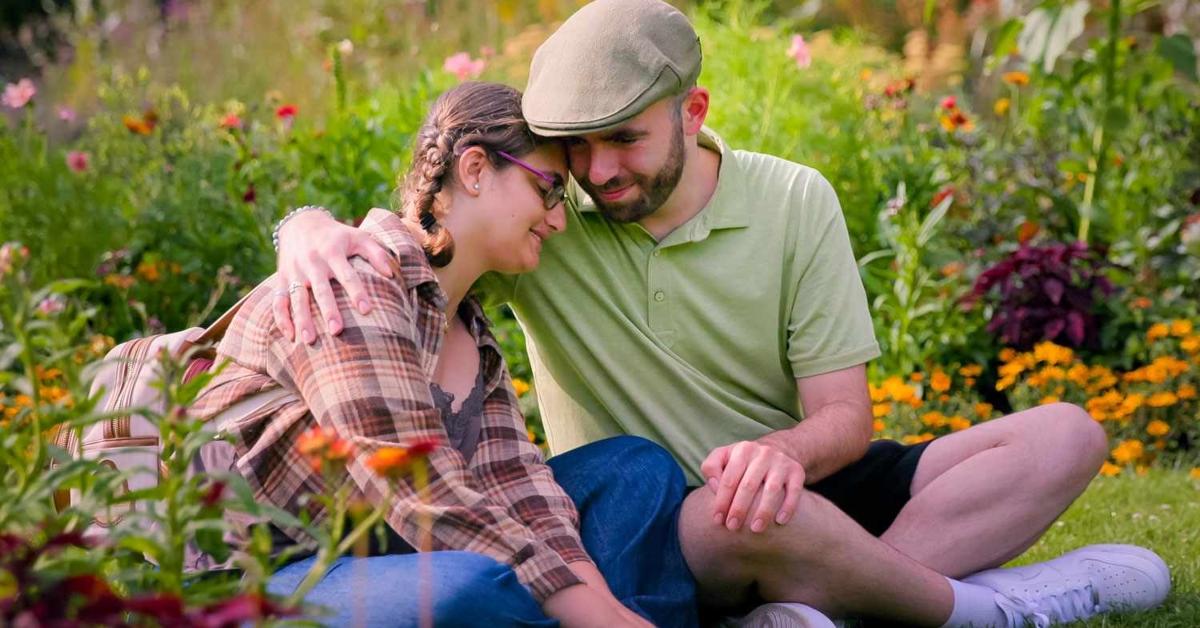 Connor and Georgie sit in a field of flowers together on Love on the Spectrum.