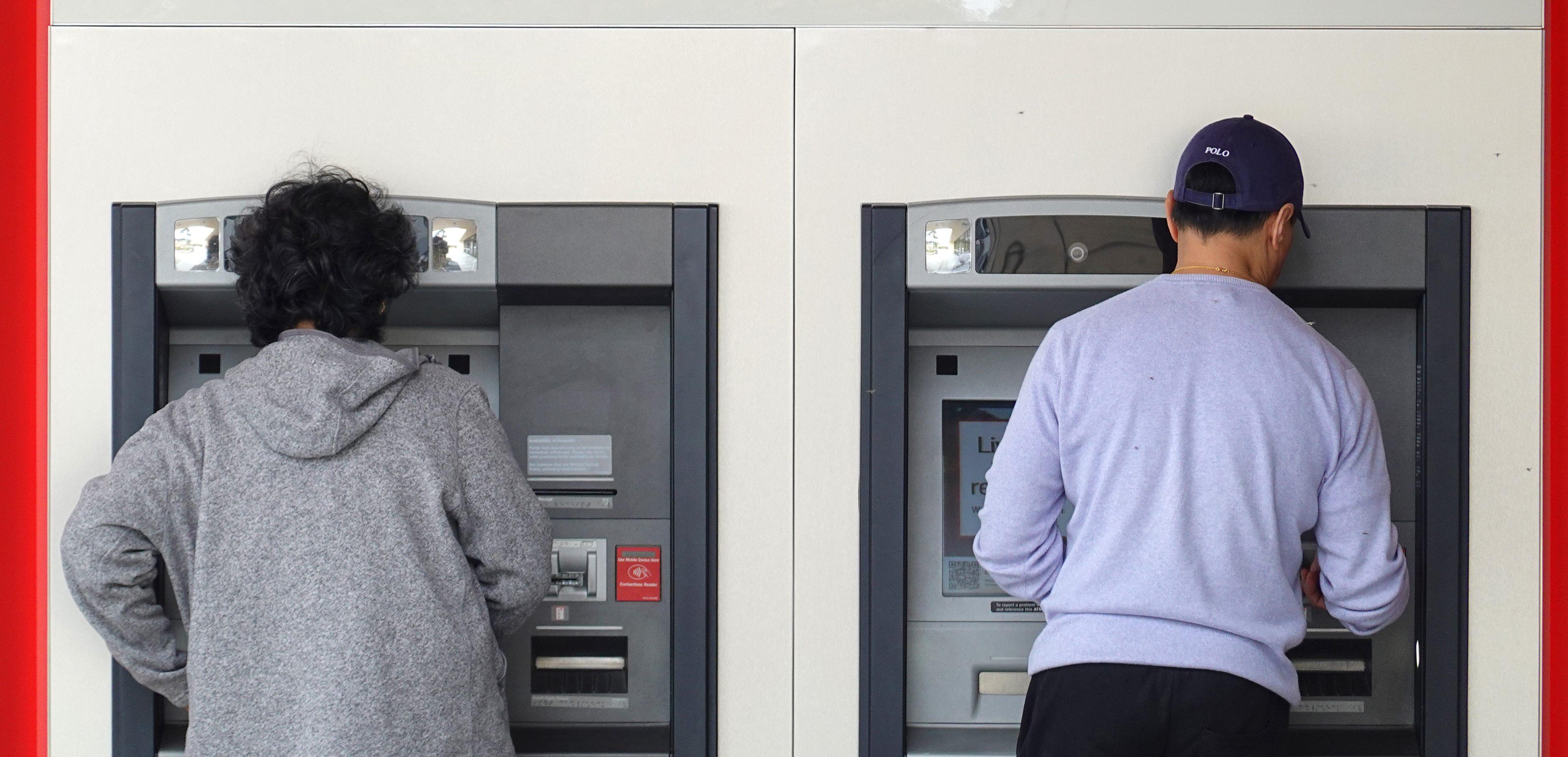 Customers use an ATM at a Bank of America office