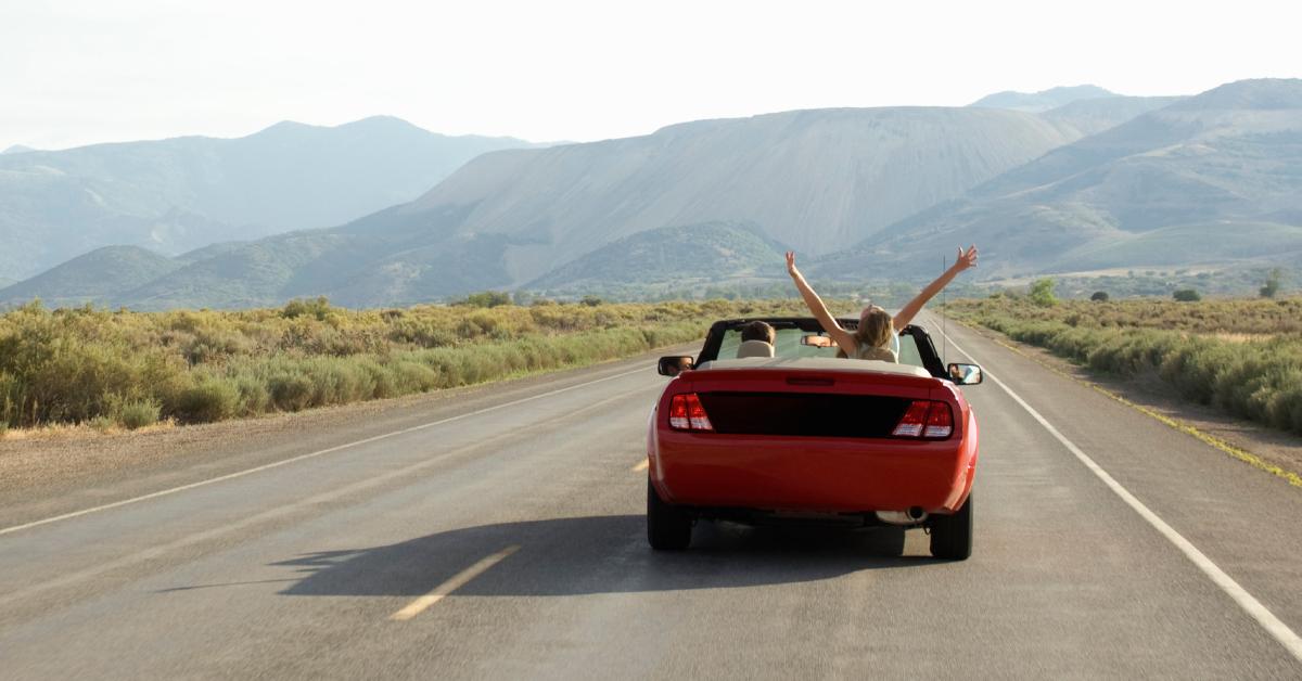 Red convertible on desert road.