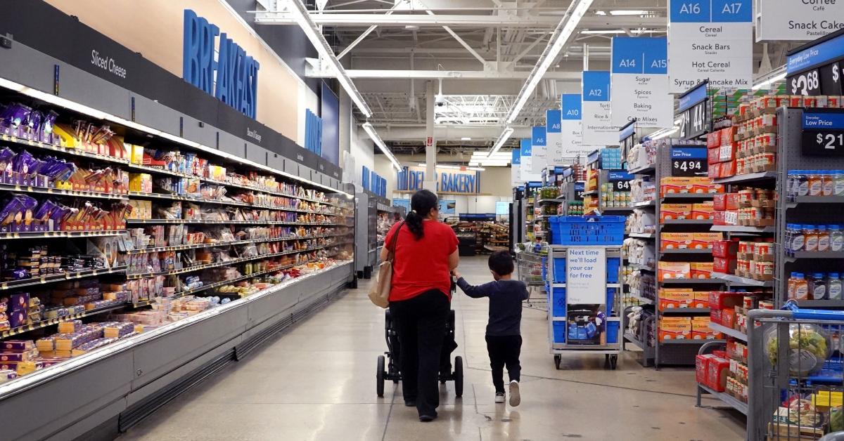 mother and son shopping in the frozen food aisle in walmart's grocery section 