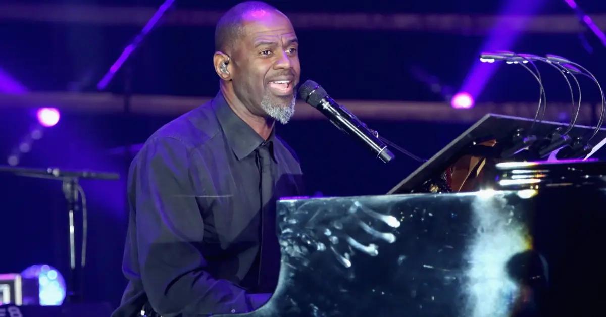 Brian McKnight signing and playing the piano on stage,