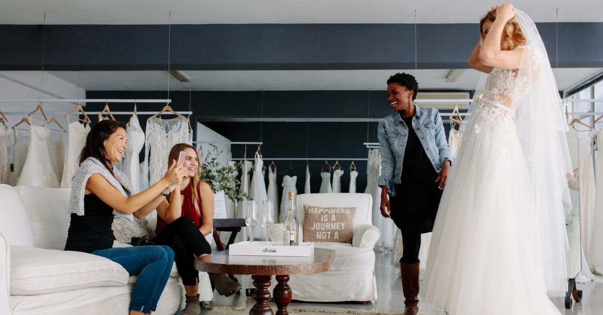 woman trying on wedding dress in a shop with friends picture id