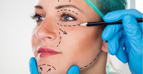 surgeon drawing lines on womans face for plastic surgery picture id