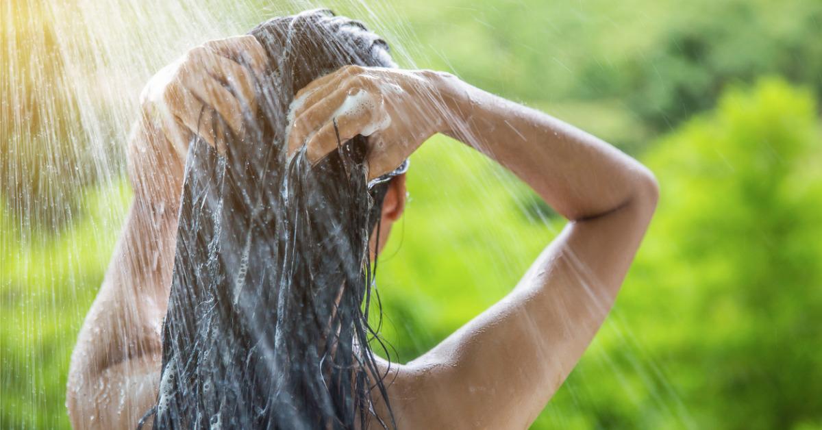 woman showering and shampooing outdoor picture id