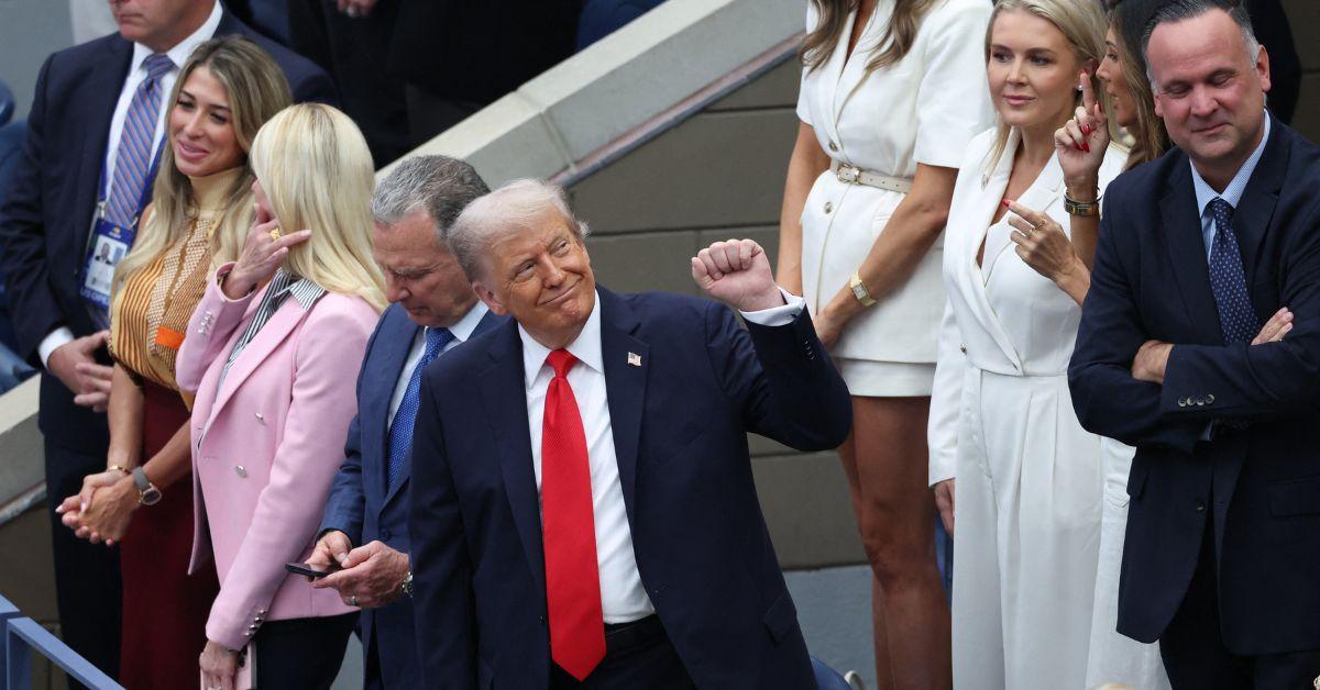 Donald Trump holding a fist up at the U.S. Open. 