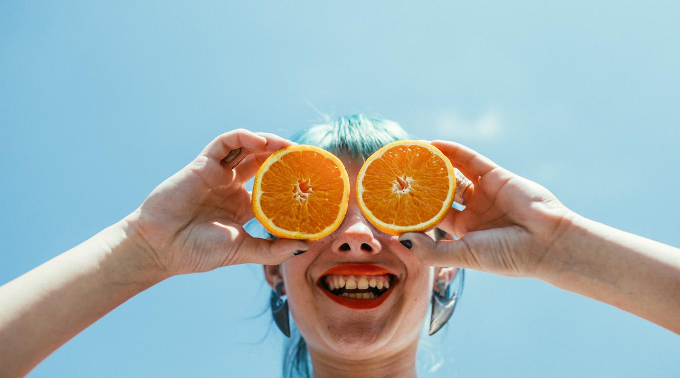 A person holding up oranges