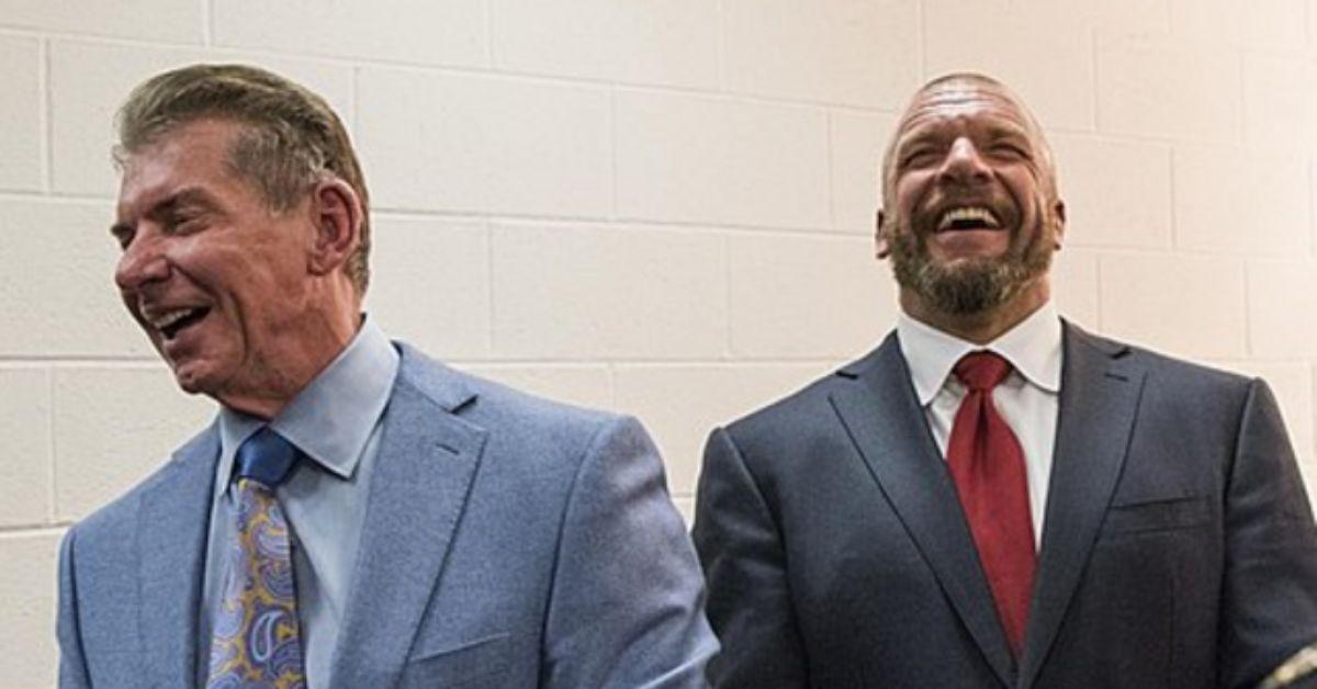 Vince McMahon and Triple H sharing a laught in a hallway. 