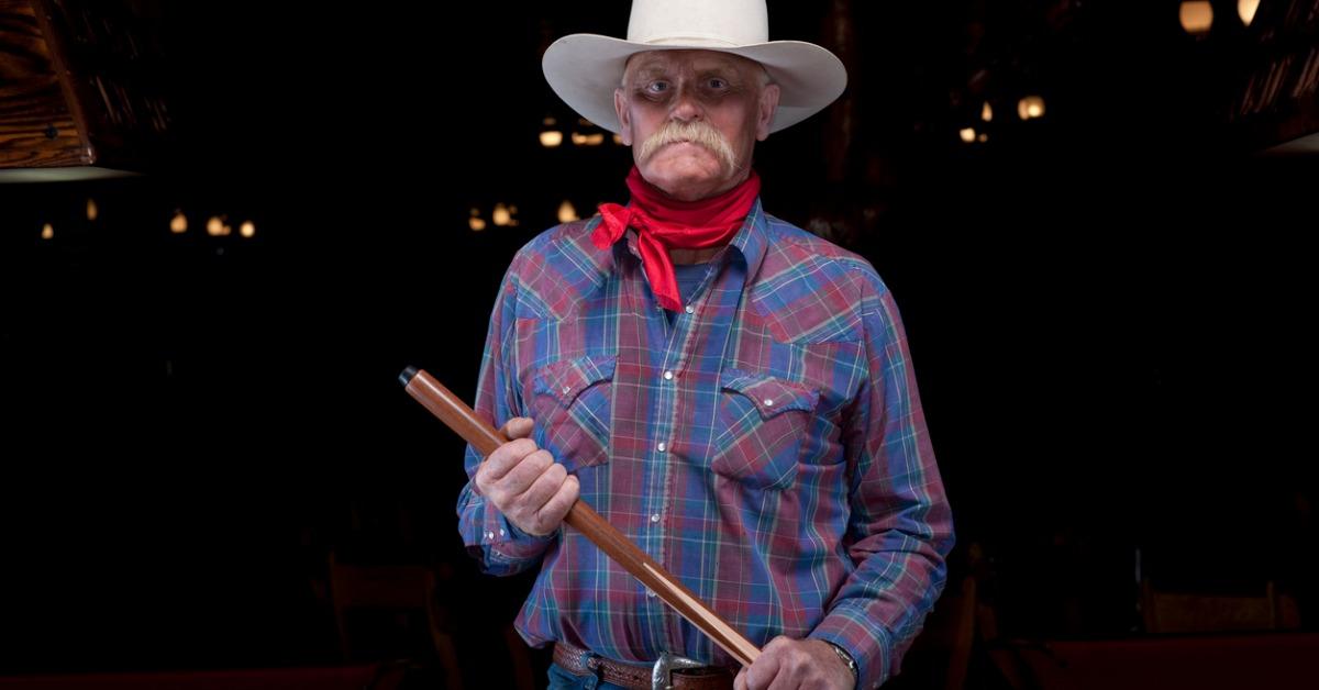 senior cowboy holding pool cue picture id