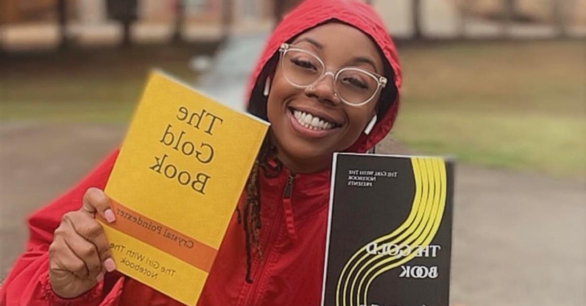 Crystal Poindexter holds up her two published volumes of 'The Gold Book'