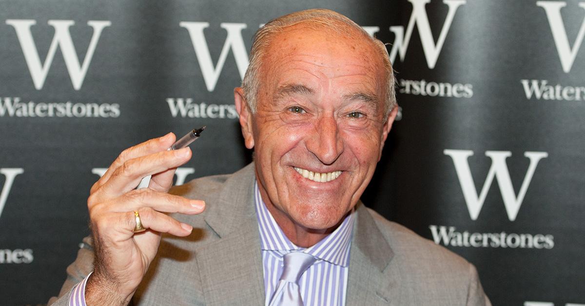 Len Goodman holding a pen on the red carpet.