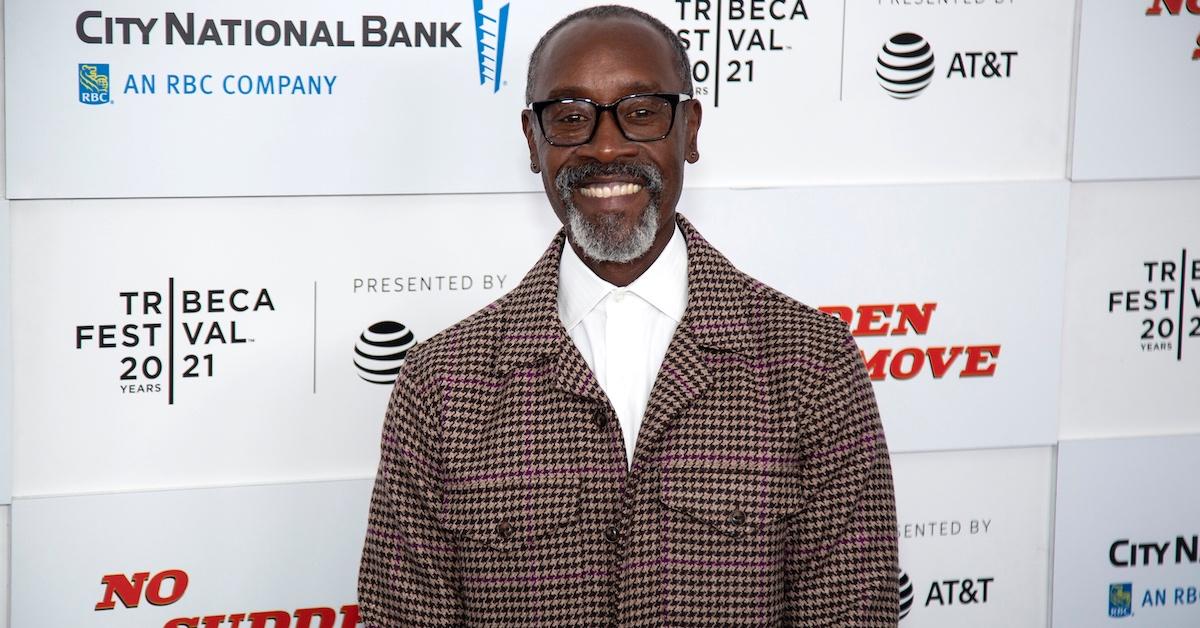 Don Cheadle attends an event wearing a plaid jacket and white shirt.