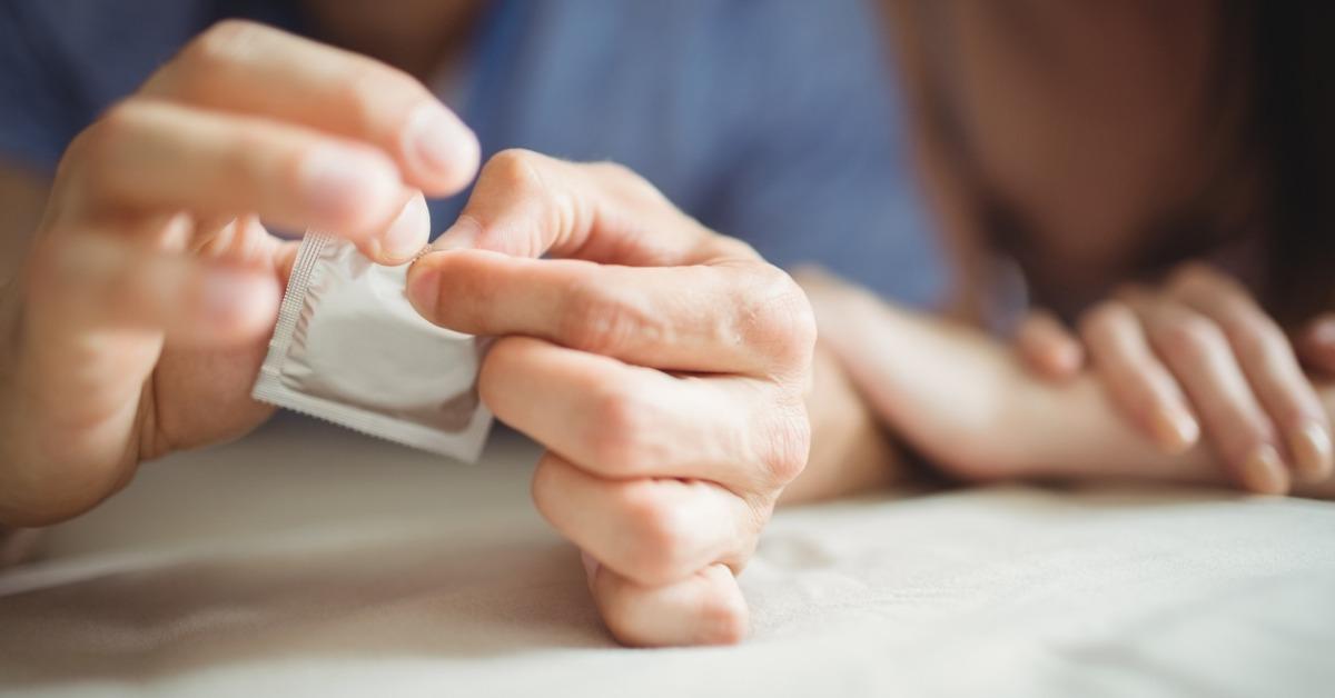 closeup of couple with a condom on bed picture id