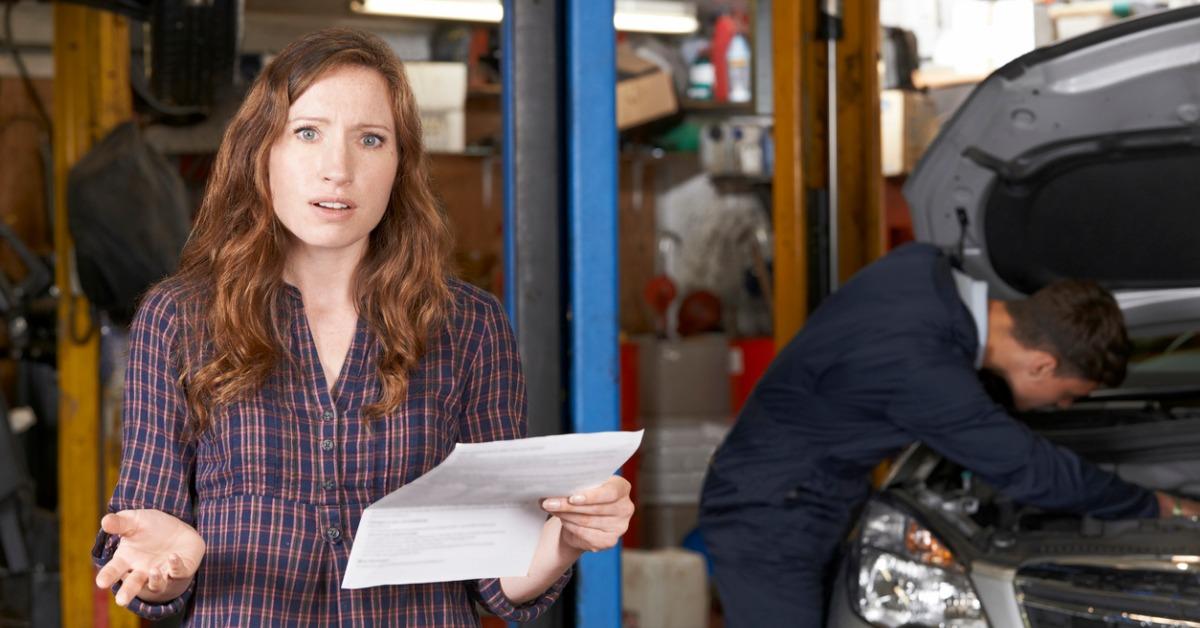 shocked female customer looking at garage bill picture id