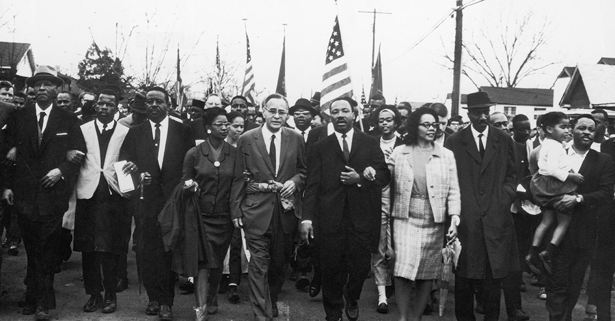 Martin Luther King, Jr. marching along with a crowd. 