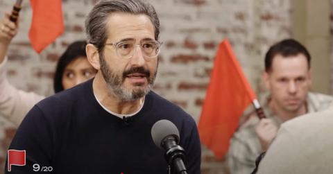 People hold up red flags during a Jubilee Media debate on 'Surrounded'