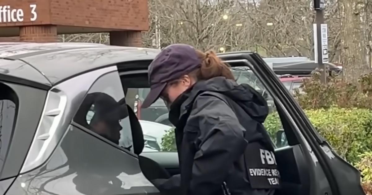 A member of the FBI's evidence team examines the vehicle belonging to two shooting victims in Portland