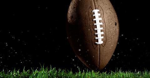 Football in motion over grass