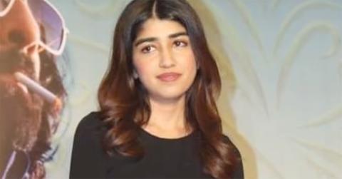 Tishaa Kumar on a red carpet in a black top.